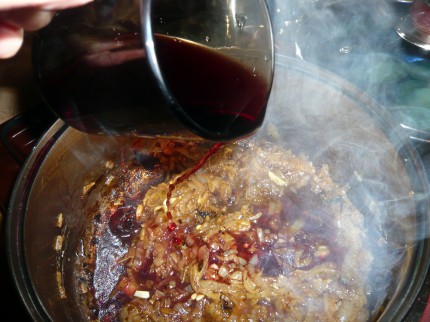 Pour red wine over the caramelized onions